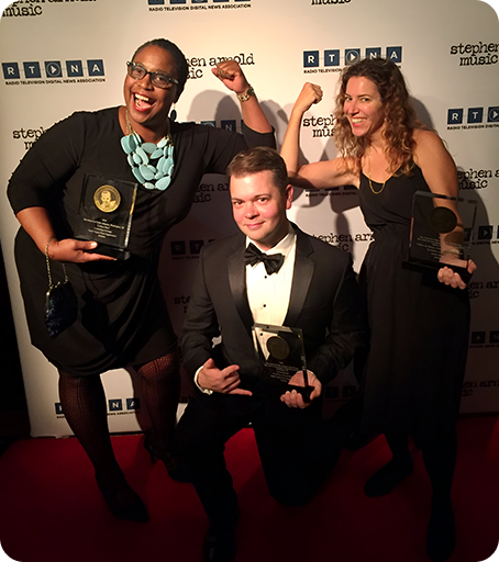 Three people posing for a picture with their awards.