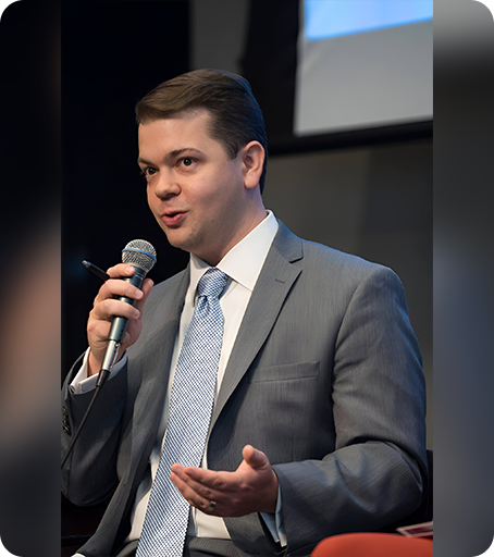 A man in a suit and tie holding a microphone.