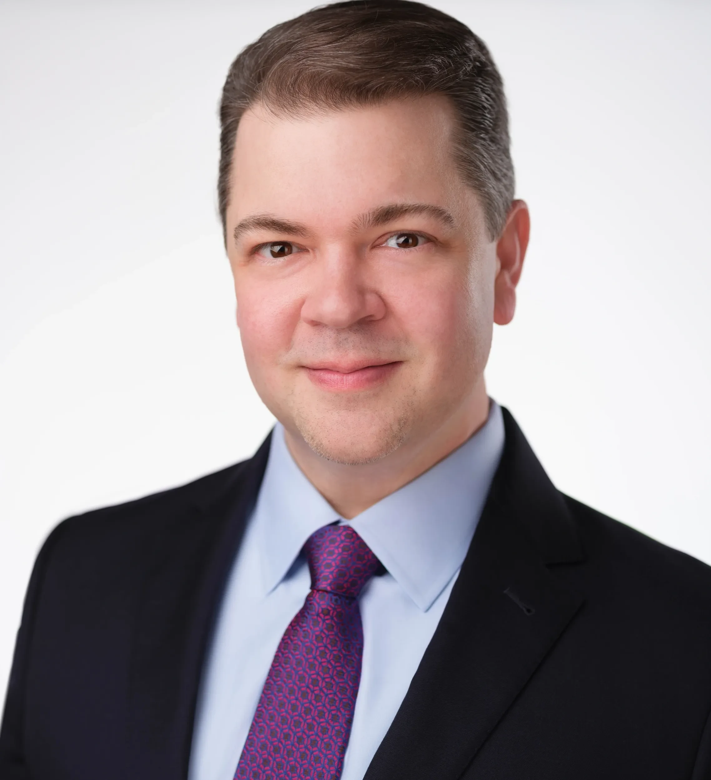 A man in a suit and purple tie.